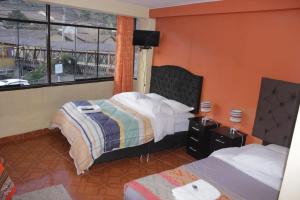 Cette chambre comprend 2 lits et une fenêtre. dans l'établissement hostal Qorisonqo inn ollantaytambo, à Ollantaytambo