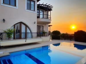 ein Haus mit einem Pool vor einem Sonnenuntergang in der Unterkunft Sunset Serenity room with ensuite No1 The Lanterns in Kyrenia