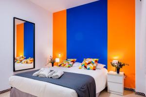 a bedroom with a blue and orange wall at Anfitrión Sevilla 6 in Seville