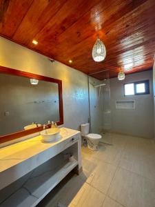 a bathroom with a sink and a toilet and a mirror at Bem te quero Pipa- apt superior in Pipa +21 photos