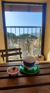 una taza de café sentada en una mesa frente a una ventana en Happy Home Hosting en Rieti