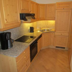 a kitchen with wooden cabinets and a sink and a stove at Juniorland II in Wagrain