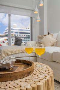 two wine glasses sitting on a table in a living room at Experience The Groovy Harbour House Lifestyle in Oranjestad