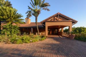 a house with a palm tree and a brick driveway at San Lameer Villa 12405 - 2 Bedroom Classic - 4 pax - San Lameer Rental Agency in Southbroom