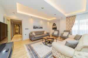 a living room with couches and a flat screen tv at Comfy Flat with Balcony Close to Konyaalti Beach in Antalya