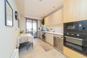 a kitchen with a table and a stove top oven at Comfy Flat with Balcony Close to Konyaalti Beach in Antalya