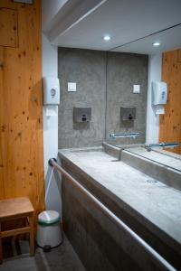 ein öffentliches Bad mit einer Theke und einem Spiegel in der Unterkunft Wax Hostel in Faro