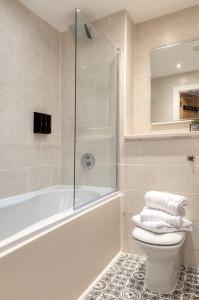 ein Bad mit einer Badewanne, einem WC und einer Dusche in der Unterkunft City Centre Apartment - Ideal for longer stays in Manchester