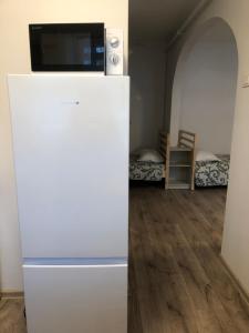 a white refrigerator with a television on top of it at Restoranas - Svečių Namai - Restaurant - Guest House Perkūnkiemis in Elektrėnai