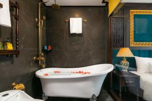 a bathroom with a bath tub and a bed at Nostalgia Halong Cruise in Ha Long