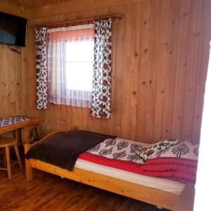 a bed in a wooden room with a window at Agroturystyka u Marii in Białka Tatrzańska