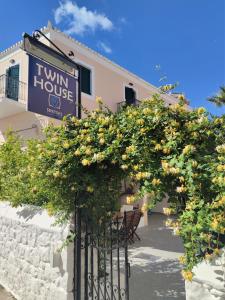 a sign for a tiny house with orange trees at Twin House Spetses in Spetses