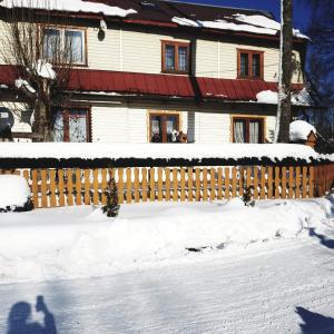 a fence covered in snow in front of a house at Agroturystyka u Marii in Białka Tatrzańska