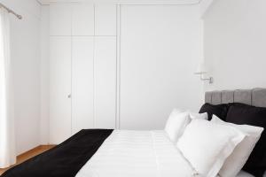 Schlafzimmer mit weißen Wänden und einem Bett mit weißen Kissen in der Unterkunft Acropolis Urban Life in Athen