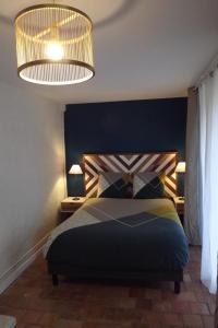 a bedroom with a bed with a blue headboard and two lamps at Chambres d'hôtes La Tour de Bellevue et son jacuzzi in Saumur