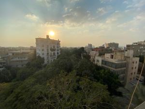 una vista de una ciudad con la puesta de sol detrás de los edificios en Cozy Room with an amazing view in Maadi, en El Cairo