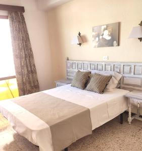 Un dormitorio con una gran cama blanca y una ventana en Hostal Santa Ana en Lloret de Mar