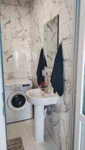 a bathroom with a sink and a washing machine at Good Inn in Bar