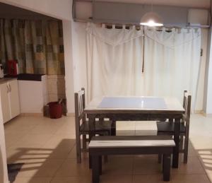 uma mesa e cadeiras num quarto com uma janela em Floma em Neuquén