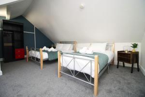 una camera con due letti in mansarda di Stunning 4 Bedroom Flat - Near City Centre a Swansea