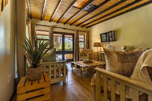 a living room with wooden furniture and a ceiling at Wilderness Metanoia in Wilderness