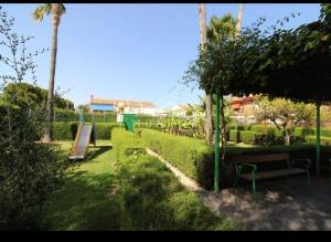 een park met een bank en een schommel bij Appartement proche mer in Santiago de la Ribera
