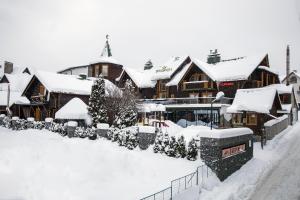 un edificio cubierto de nieve con un patio cubierto de nieve en Korona Hotel&SPA en Bukovel