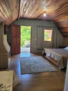 - une chambre avec un lit et un plafond en bois dans l'établissement Chalé Mantiqueira, à Piranguçu
