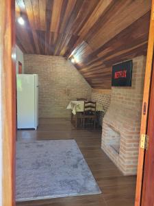 Cette chambre est dotée d'un mur en briques et d'un réfrigérateur. dans l'établissement Chalé Mantiqueira, à Piranguçu