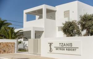 un edificio bianco con un cartello notturno di Tams Sydney di Tzanis Resort Skyros a Skiros