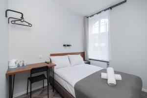 een slaapkamer met een bed, een bureau en een raam bij Zefiro Seredyńskiego in Gdańsk