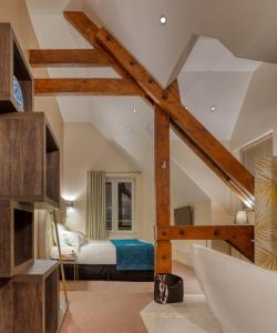 een slaapkamer op zolder met een bed en houten balken bij Hôtel L'Orée des plages in Clohars-Carnoët