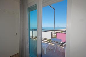 a room with a balcony with a view of the ocean at Hotel Kent in Riccione