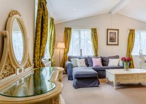 a living room with a blue couch and a mirror at Bluewood Lodges in Kingham