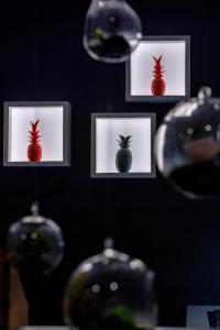 a wall with three pictures of a strawberry in frames at Hôtel Méditerranée in Calvi