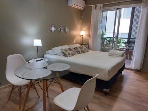 a bedroom with a bed and two tables and chairs at Balcones Verdes 2407 in Salta