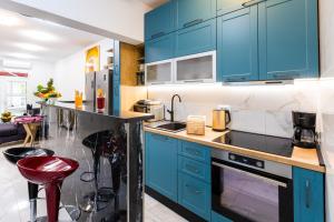 Una cocina con gabinetes azules y un taburete rojo. en Apartment Zolla Dubrovnik- Hot Tub and Free Parking, en Dubrovnik