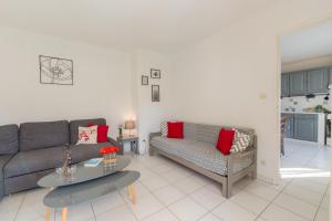 a living room with two couches and a table at Le Verger, villa lumineuse et agréable avec son espace extérieur clos au cœur de notre vignoble in Hyères