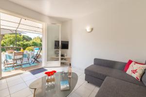 uma sala de estar com um sofá e uma mesa em Le Verger, villa lumineuse et agréable avec son espace extérieur clos au cœur de notre vignoble em Hyères