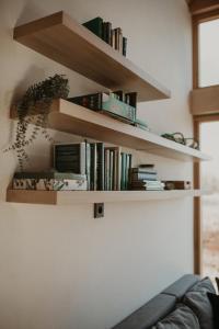 a book shelf on a wall with books at Niebieski Domek nad jeziorem Mazurskie klimaty in Pogubie Tylne