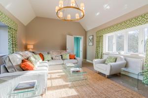 Quarry Lodge في ليدني: غرفة معيشة بها أريكة وكراسي وثريا