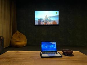 a laptop computer sitting on a wooden table with a tv at Hotel Eden in Mestia