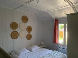 ein Schlafzimmer mit einem weißen Bett und einem Fenster in der Unterkunft Cottage les petites voiles plage in Agon Coutainville