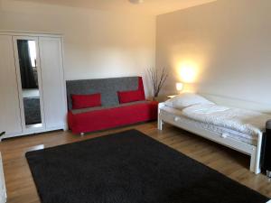 Fewo 2 في Nortorf: غرفة معيشة مع أريكة حمراء وسرير