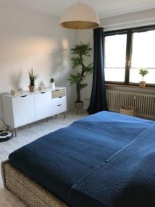 a bedroom with a blue bed and a dresser and windows at Fewo 3 in Nortorf