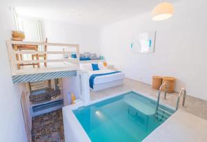 a room with a bed and a swimming pool at Pylaia Boutique Hotel & Spa in Astypalaia