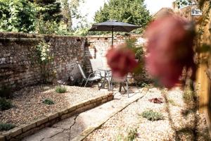 um jardim com uma mesa e um guarda-sol em Braybrooke Cottage, Saffron Walden em Saffron Walden
