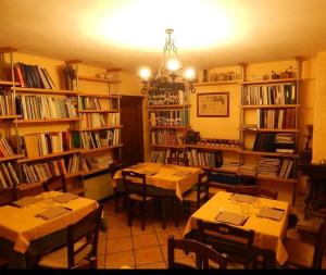 a dining room with tables and shelves of books at Agriturismo Fonte Magria in Abbadia San Salvatore