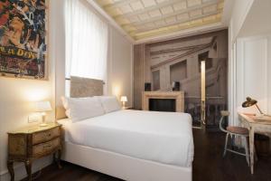 a white bedroom with a white bed and a fireplace at BDB Rooms Trastevere in Rome