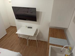 Milash في Karaburma: غرفة صغيرة مع طاولة بيضاء وتلفزيون على الحائط